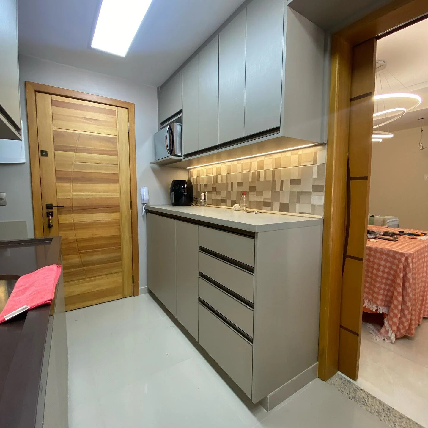 Cozinha linear planejada em tons de cinza e madeira